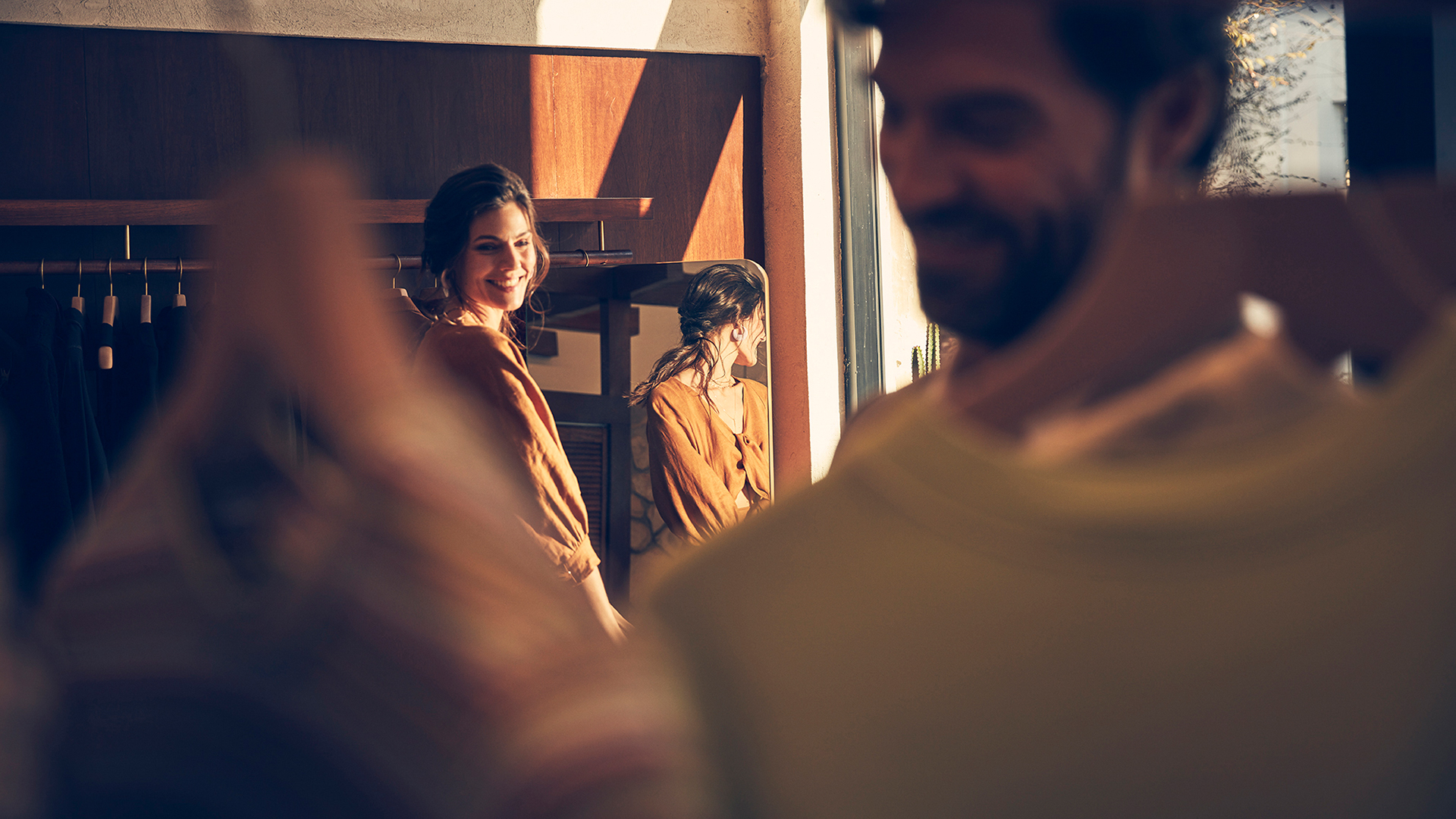 A women and man perusing clothing in a shop.