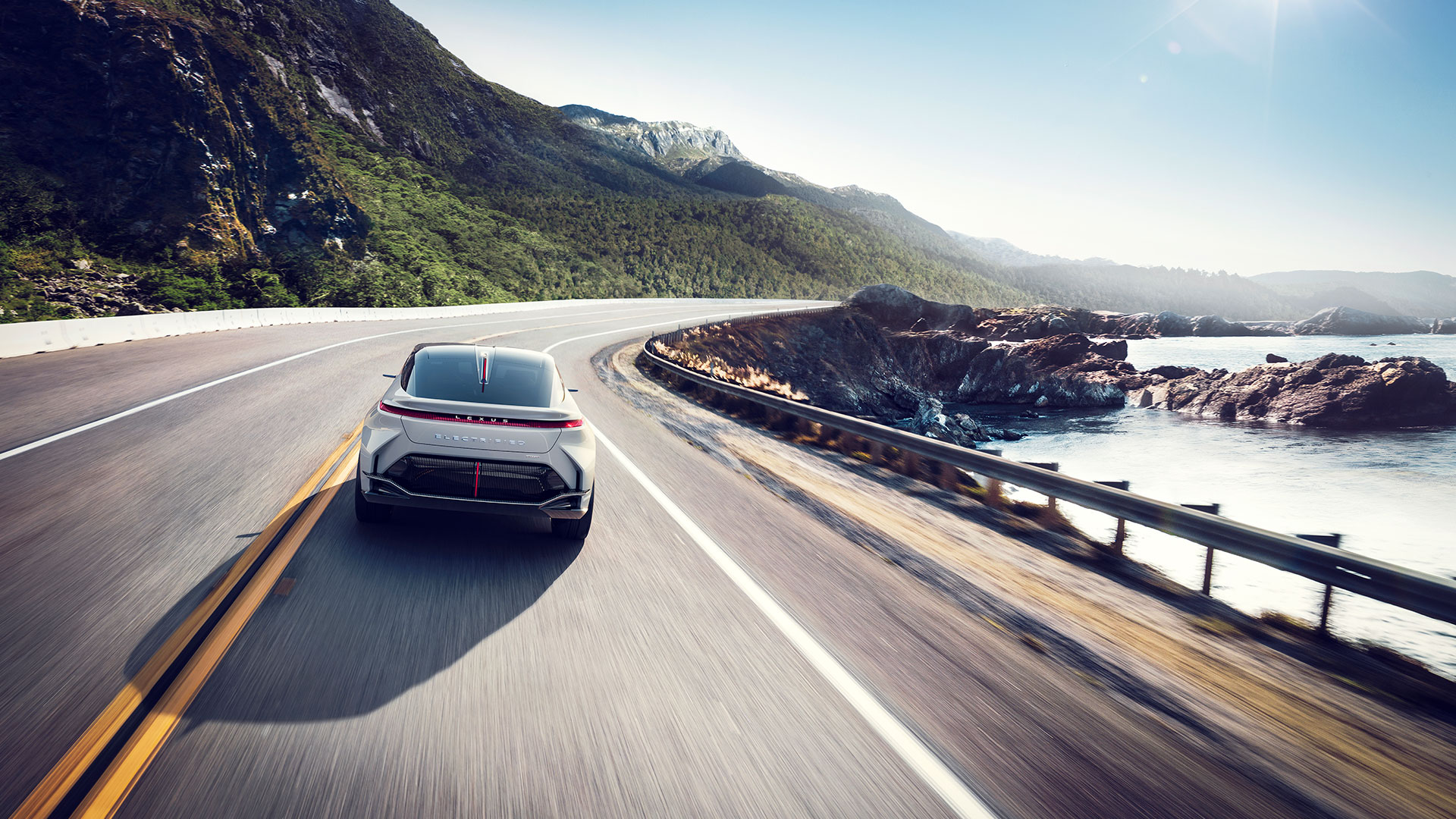 White Lexus vehicle driving along a coastal road