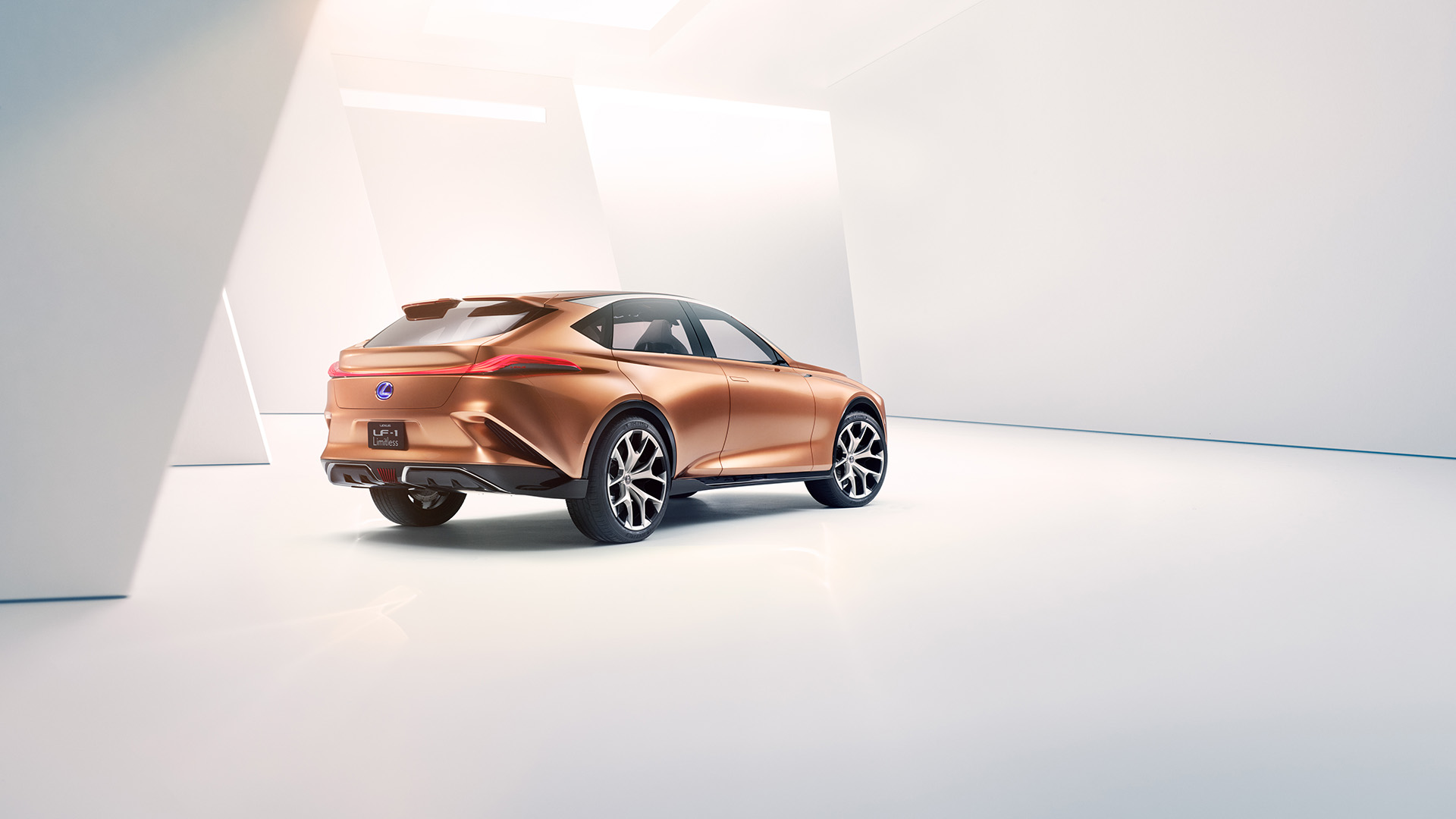 Rear view of a copper Lexus LF-1 Limitless concept vehicle parked in a white room