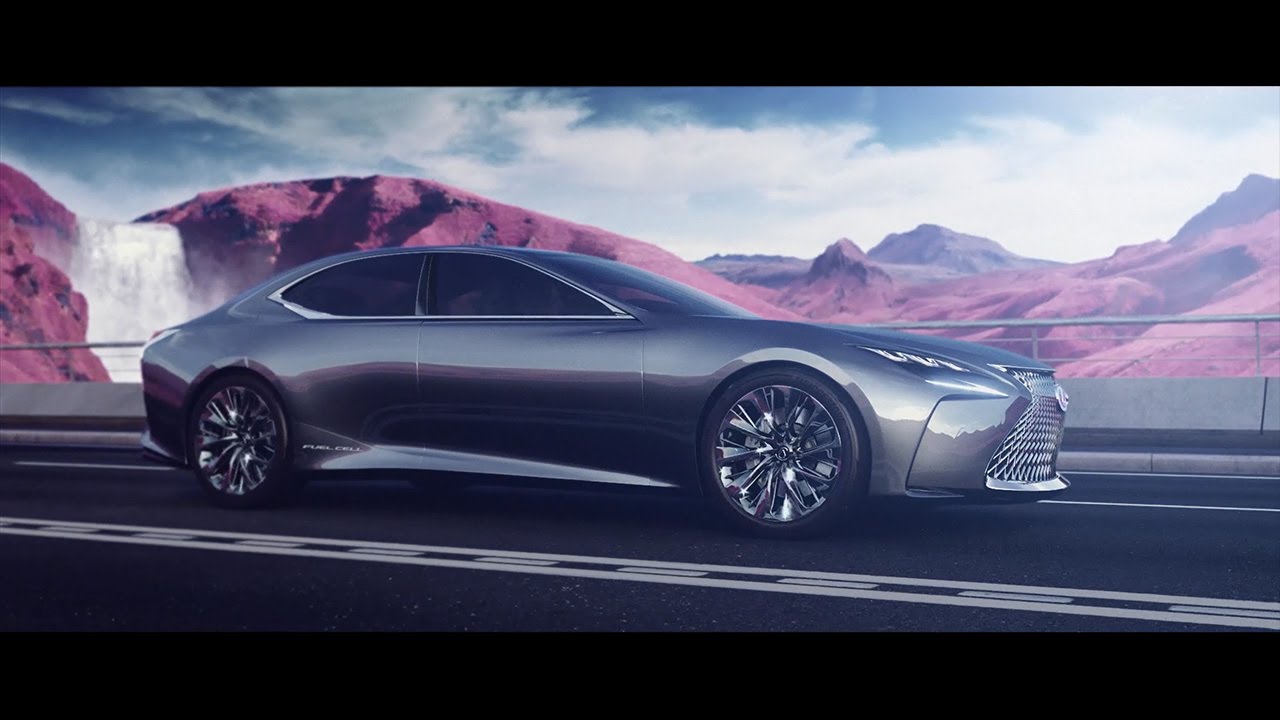 Black Lexus LF FC car driving along a road with mountainous background.