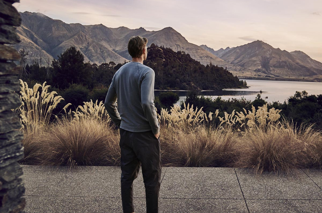 Man looking at a lake with mountains in the background