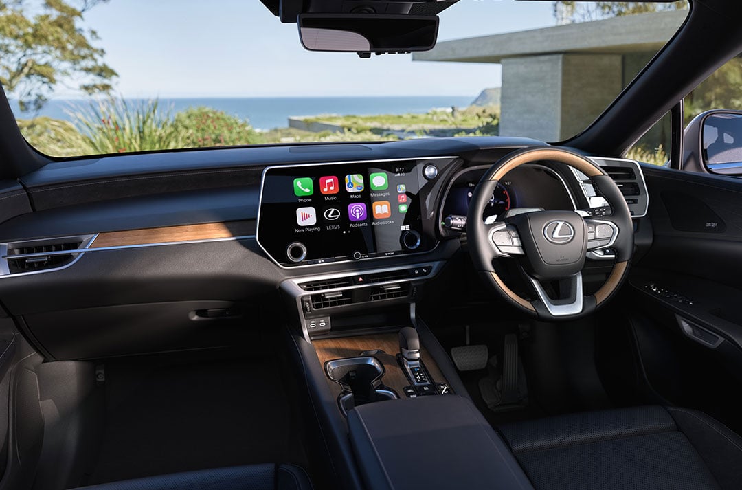 Interior of a Lexus RX showing the driver’s cockpit, steering wheel and central touchscreen