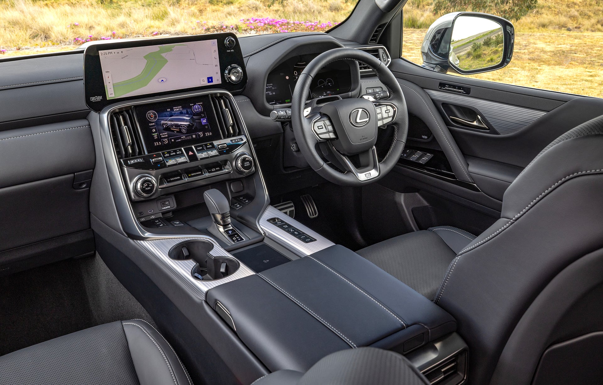 Interior view of the Lexus LX 700h cabin showing the driver’s cockpit, and infotainment displays.