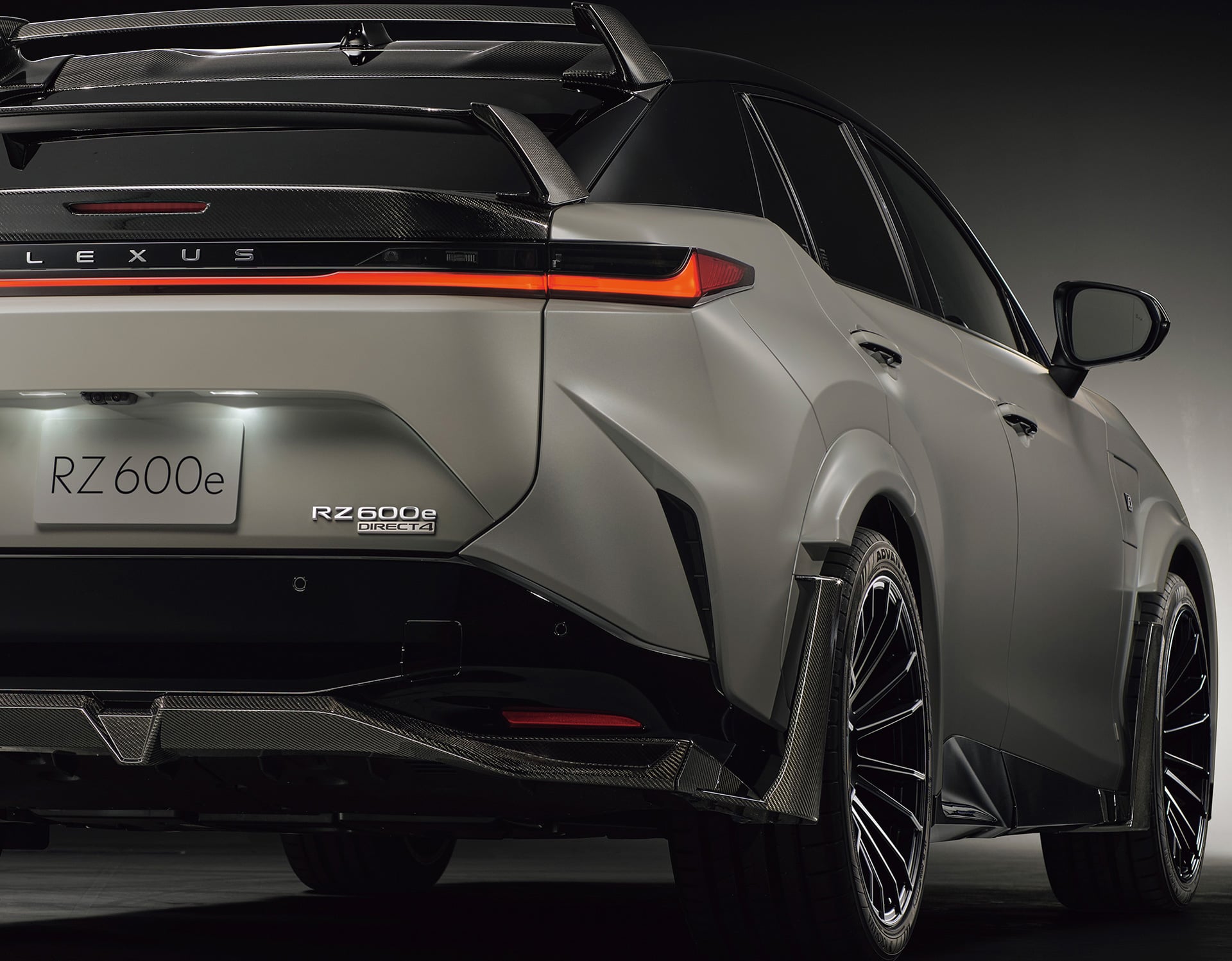Rear view of a white Lexus RZ 600e F Sport Performance in a studio setting