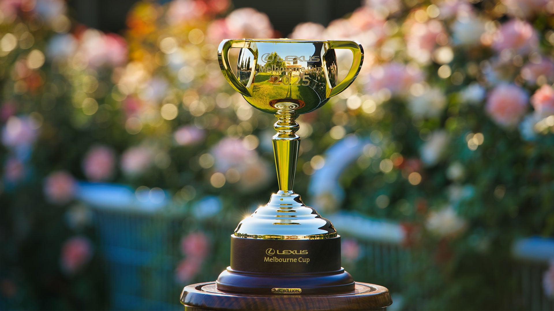 The golden Lexus Melbourne Cup 2025 trophy with flowers in the background