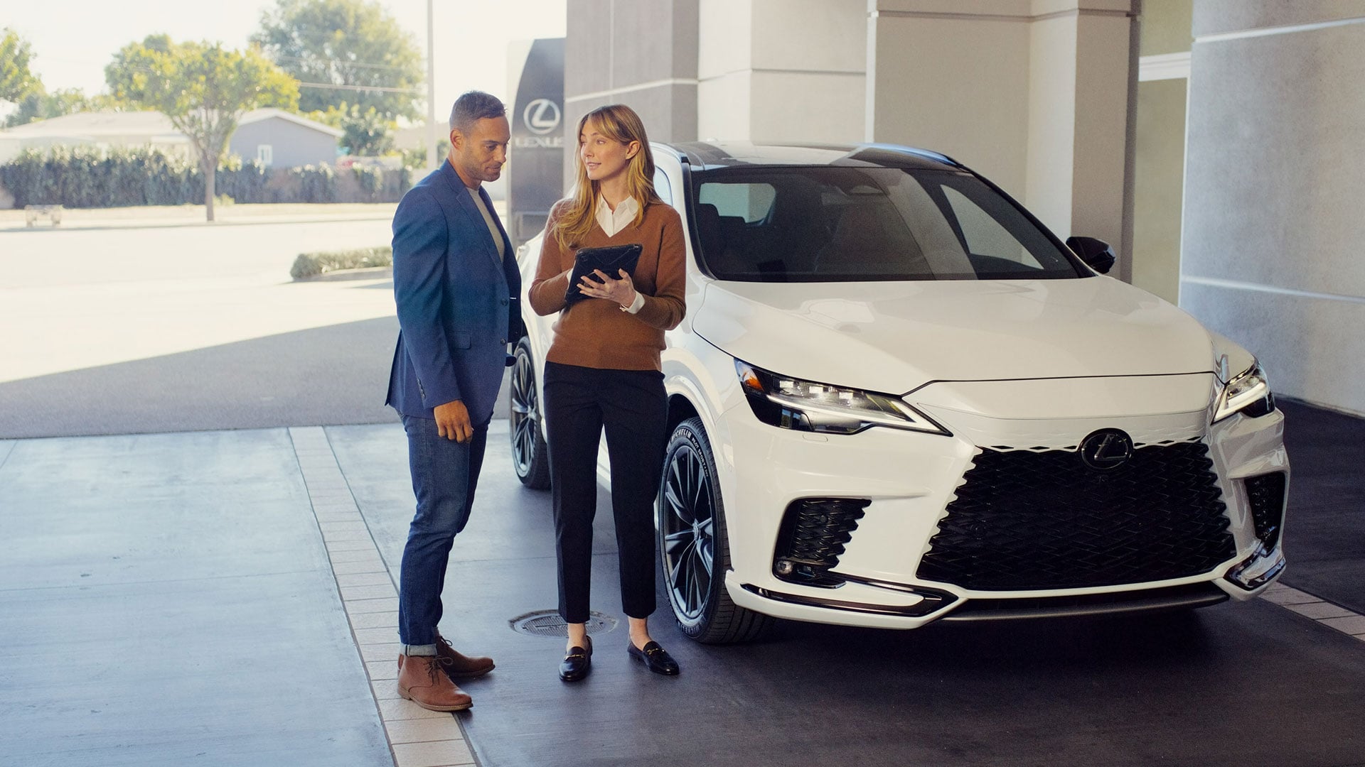 White Lexus RX vehicle with a man and woman standing beside it.