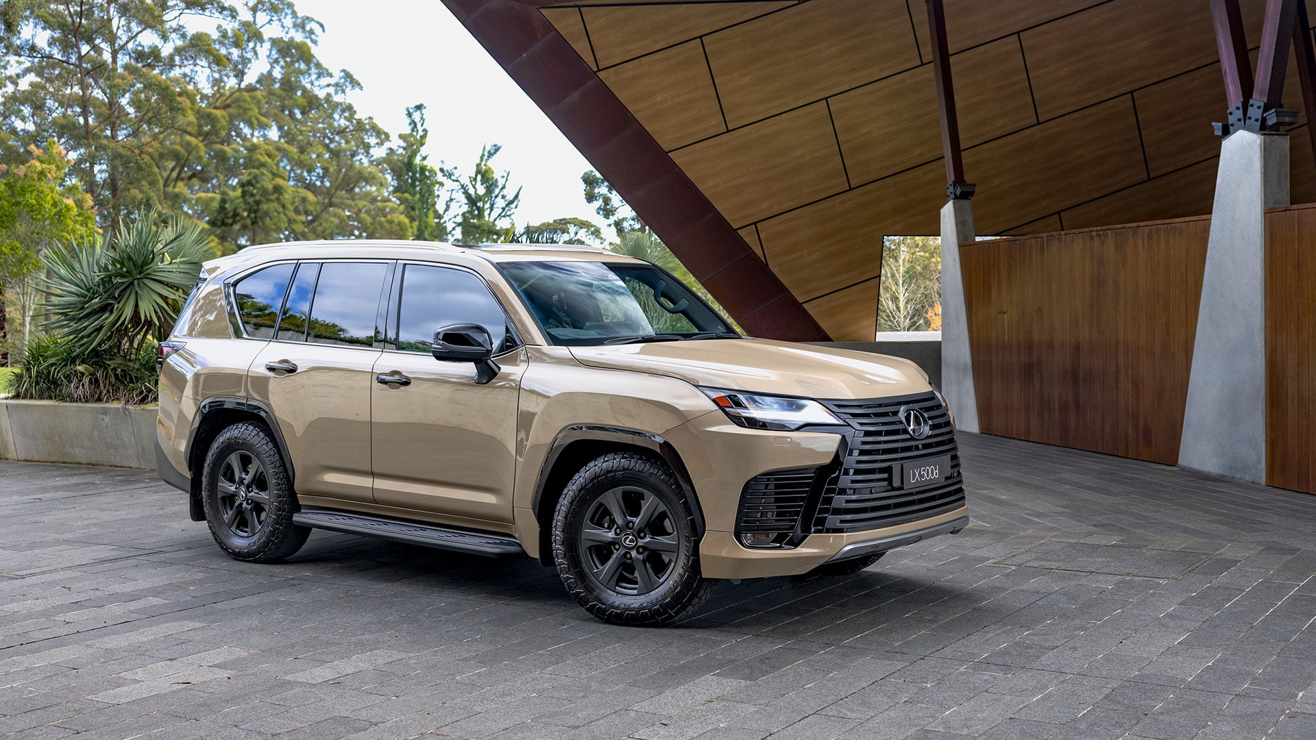 The Lexus LX 500d Overtrail in Earth tone parked outside a modern building