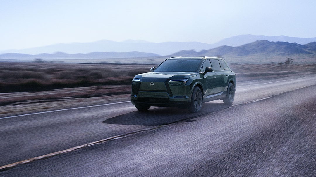 Lexus TZ driving on a road with blue mountains in the background